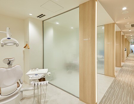 Imagen de un consultorio dental con ventanas de vidrio y paredes de madera clara renovadas con acabados de vidrio y superficie de 3M.
