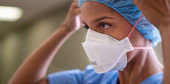 Clinician putting on a respirator
