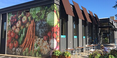 Exterior of grocery store with a 3M printable film wall graphic of fresh vegetables
