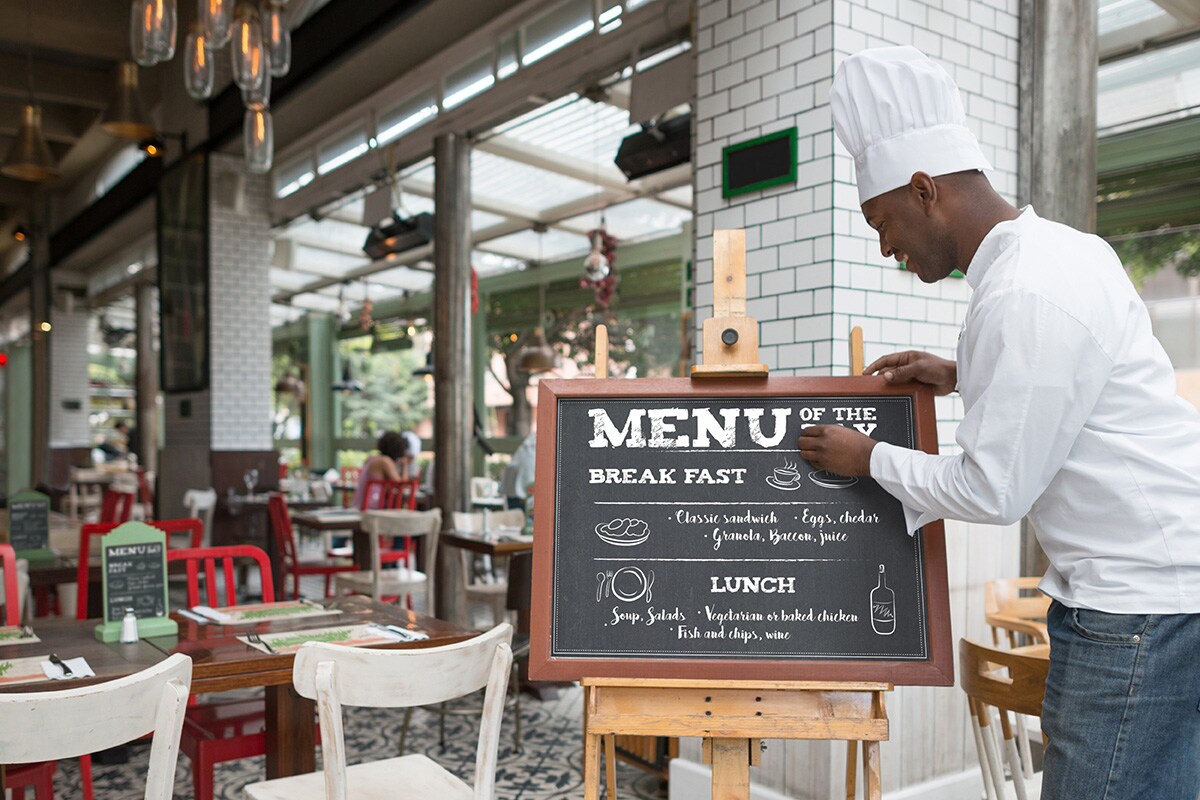 Frente del restaurante con un Chef personalizando el Menú del día. 
