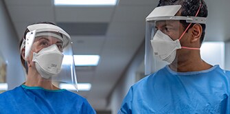 Two clinicians wearing PPE
