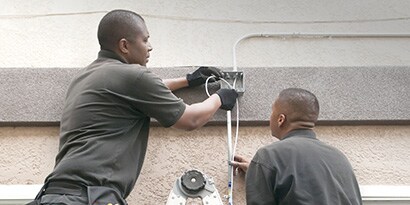 Dos electricistas que trabajan en cableado residencial.
