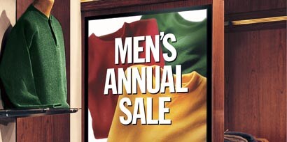View of a promotional sign for a men's annual sale with a red, green, and yellow shirt on it printed using 3M printable films.

