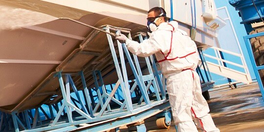 3M Respirator protecting man from gases and vapors while cleaning a boat
