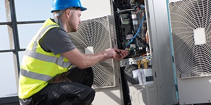 Hombre trabajando en caja de conexiones eléctricas
