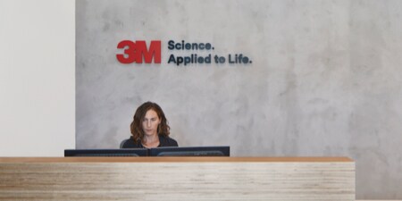 Receptionist seated at the front desk at the world headquarters entrance of 3M.
