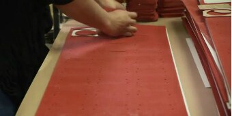 Imagen fija de video de un trabajador quitando elementos de una hoja de piezas convertidas
