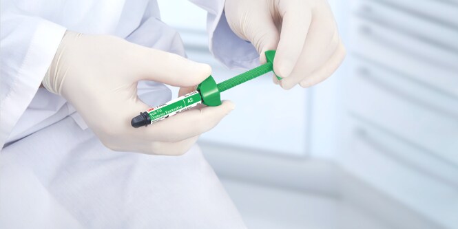 close up of hands holding 3M™ Filtek™  One Bulk Fill Restorative syringe
