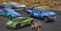 Imagen de autos de carrera verdes y azules. Camioneta azul, lancha azul y moto naranja