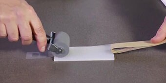 Imagen fija de video del demostrador extendiendo el adhesivo para asegurar la humectación
