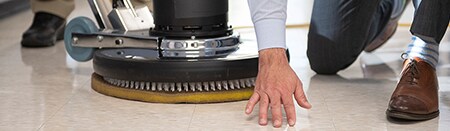 Empleado inspeccionando un suelo de hormigón recién pulido.
