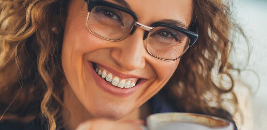 A smiling woman, wearing clear braces.
