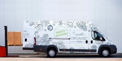 Imagen de una camionetablanca ploteada de dibujos grises y verdes
