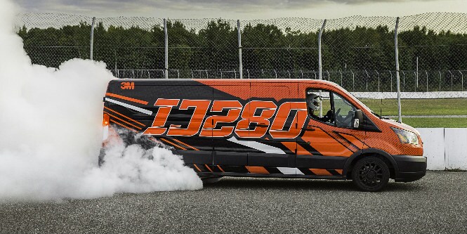 Imagen de camioneta con humo blanco por frenada. Ploteada de color naranja, negro y blanco IJ280
