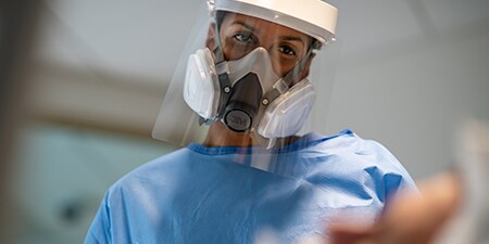 Clinician wearing a half facepiece reusable respirator

