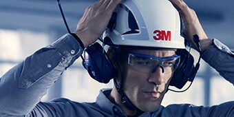 Hombre que habla por auriculares de comunicaciones protectoras 3M
