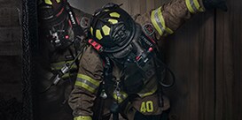 firefighters walking through a smokey building
