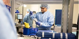 healthcare professional in protective clothing working in a lab facility setting
