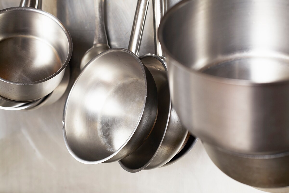 Herramientas de cocina, como ollas y sartenes, de color plateado.
